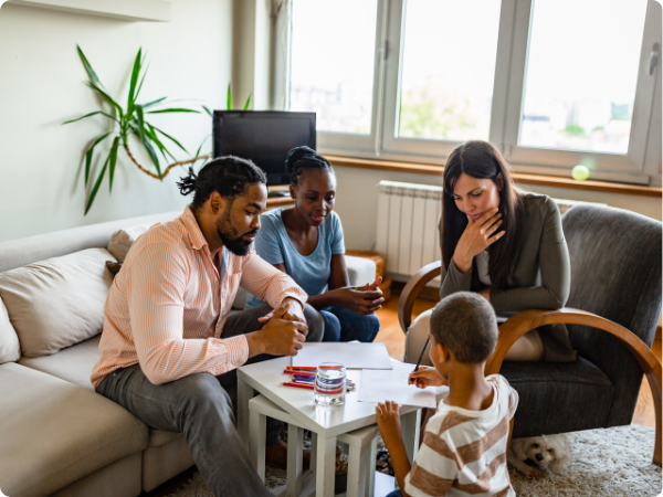 family watching a young boy draw