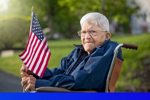 elderly male veteran holding an American flag 