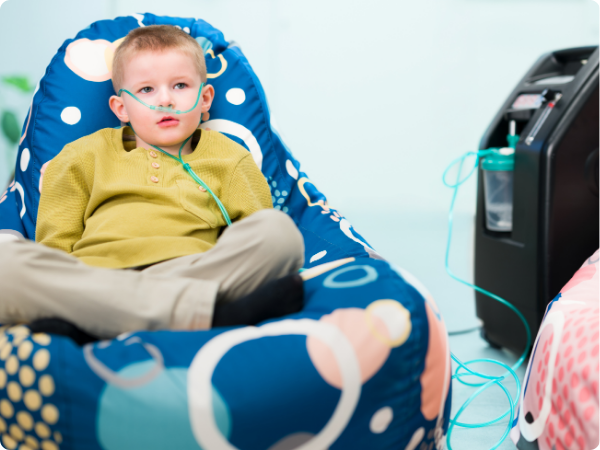 a boy connected to an oxygen machine