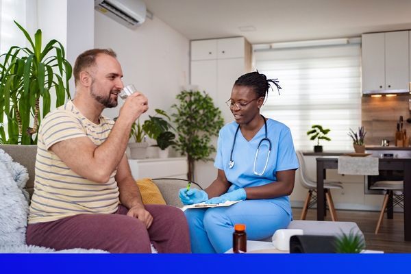 Caring professional helping middle aged man in home