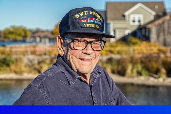 elderly man smiling with a WWII Korea Veteran hat on