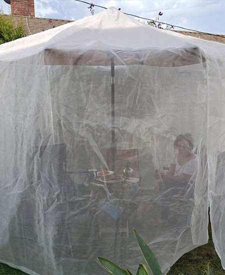 screen house product image of woman under netting enjoying a meal