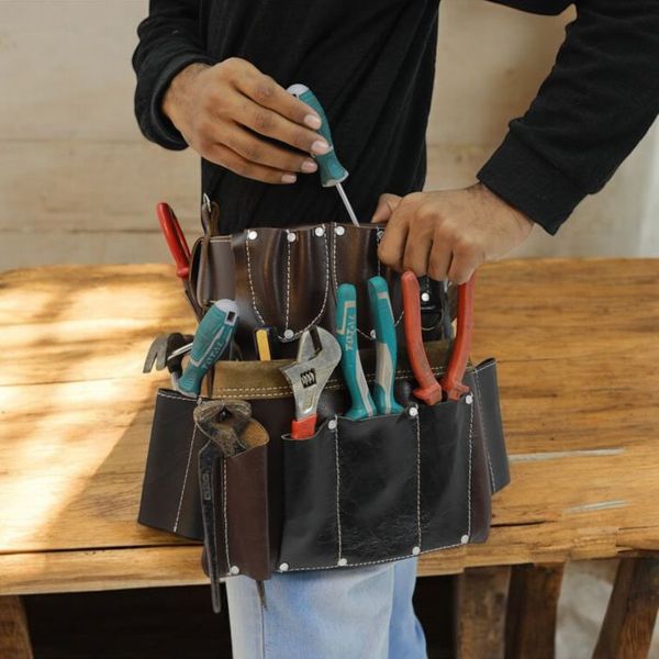 electrician puts tools into tool pouch 