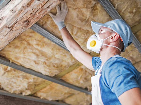 Man checking insulation in a home