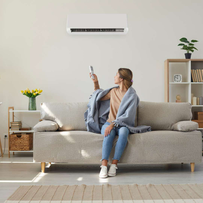 woman turning on air conditioner