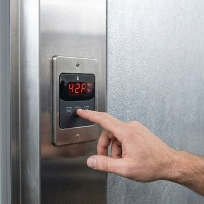 trying to adjust the thermostat on a walk in