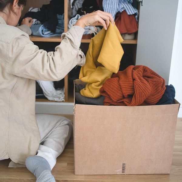 woman putting clothes in a box