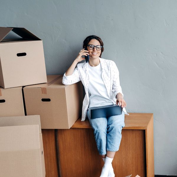 woman talking on phone next to boxes