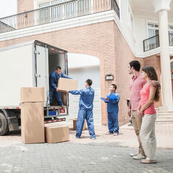 family standing by as movers unload truck