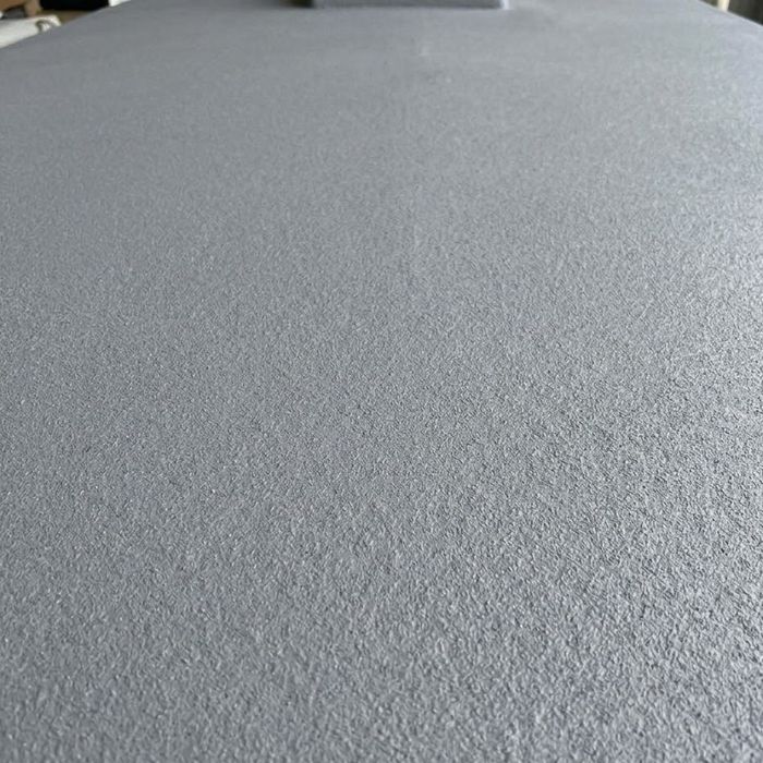 Close-up of a seamless, textured gray spray-on RV roof coating.
