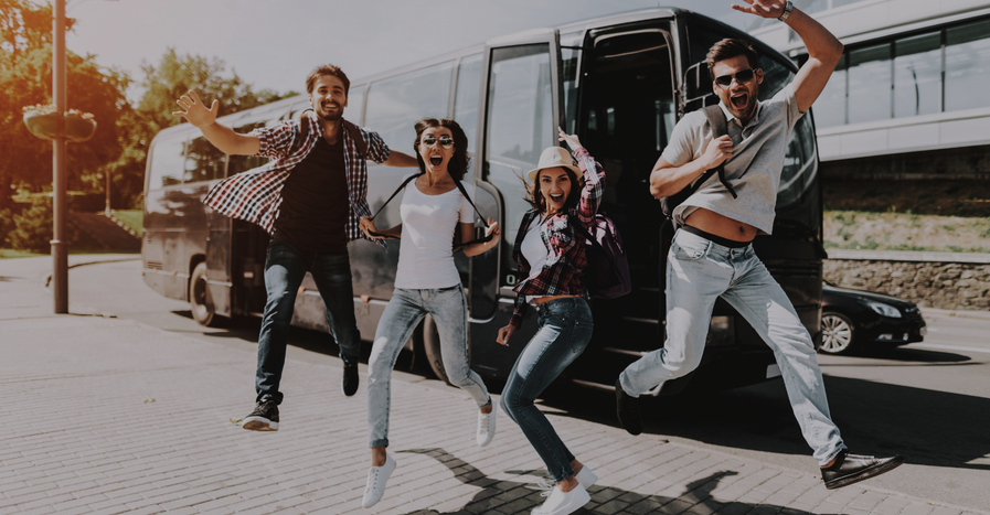 friends jumping outside of charter bus 