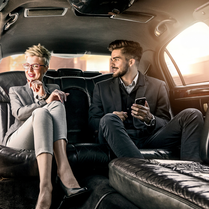 Man and woman in a luxury vehicle looking happy and relaxed. 