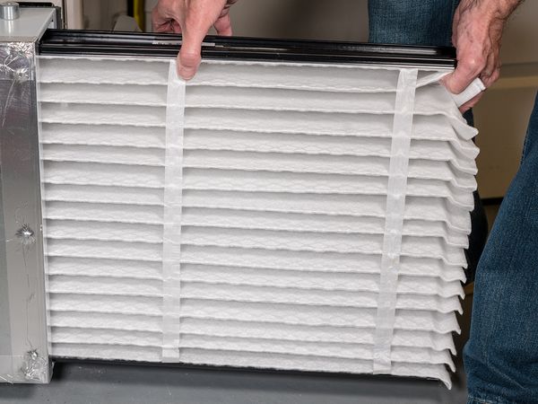 man inserting clean filter into unit