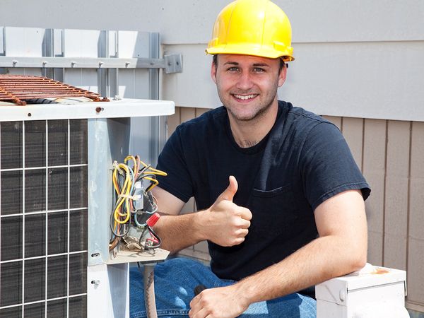HVAC tech smiling at the camera giving a thumbs up