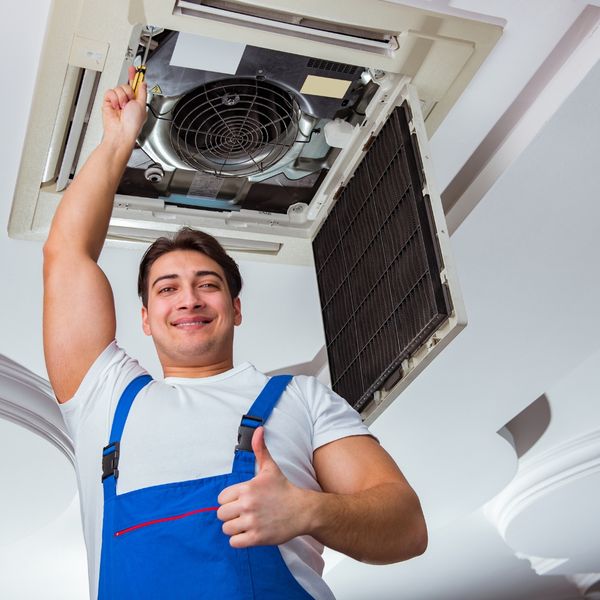 man working on hvac unit and giving a thumbs up