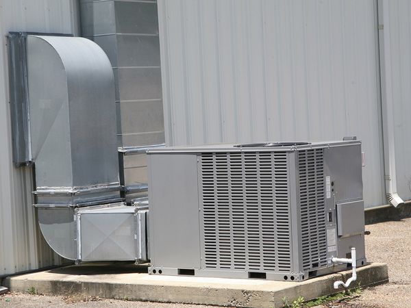 An outdoor commercial air handling unit connected to a large commercial building.