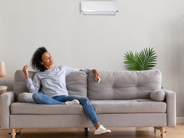 woman sitting on couch enjoying cool air