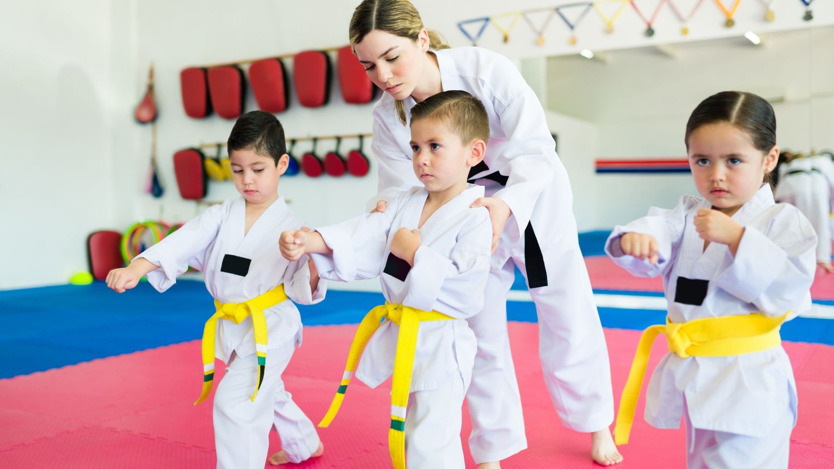 martial arts instructor helping kids 