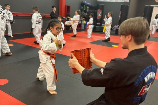 kid breaking board in karate