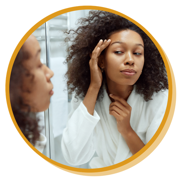 woman checking her skin in a mirror