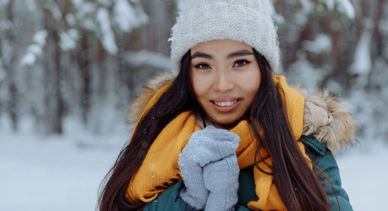 smiling woman wearing beanie and coat in the cold