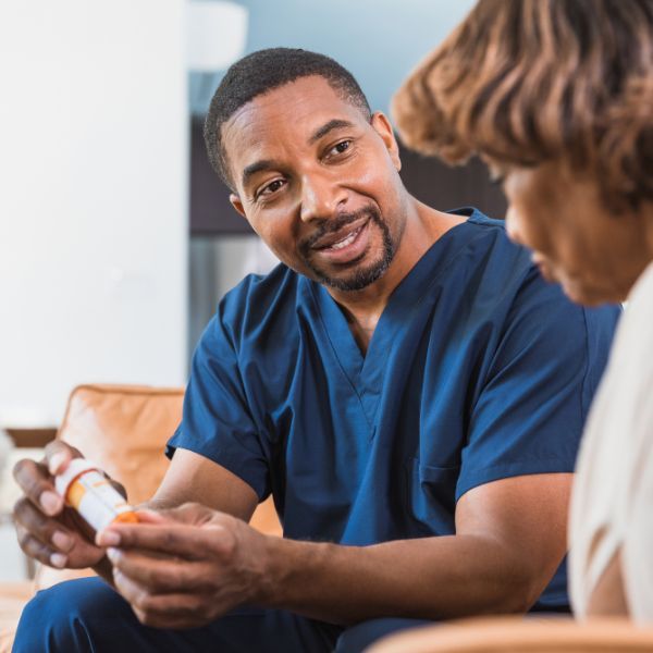 caregiver helping senior with medicine