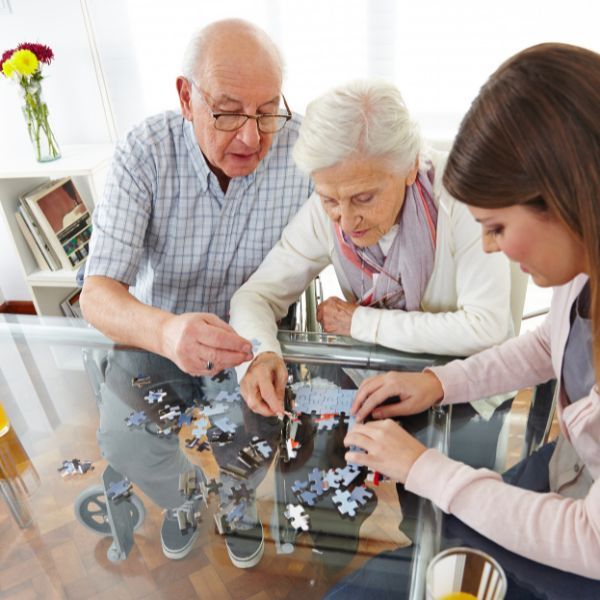 caregiver and seniors doing a puzzle