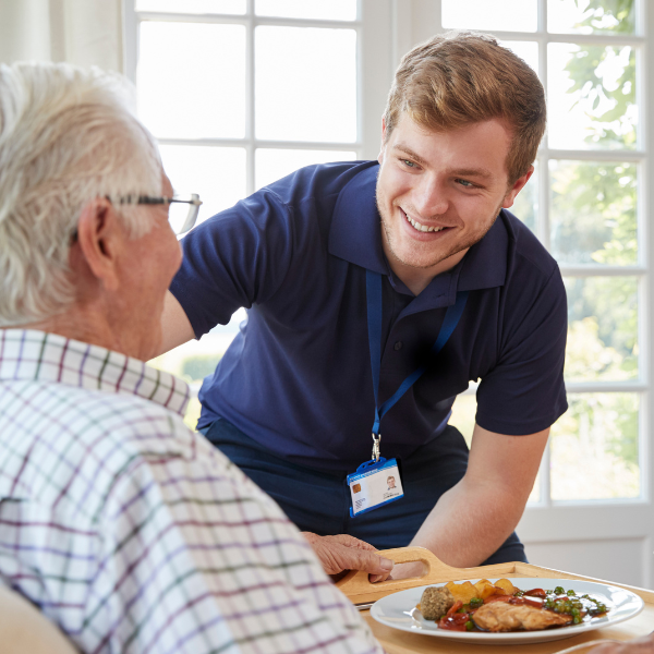 caregiver giving senior meal