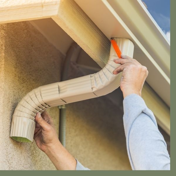 Contractor installing gutter down spout