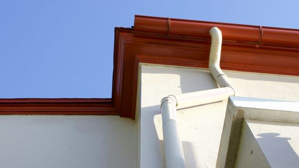 Seamless gutter system on a house directing rainwater away from the foundation.