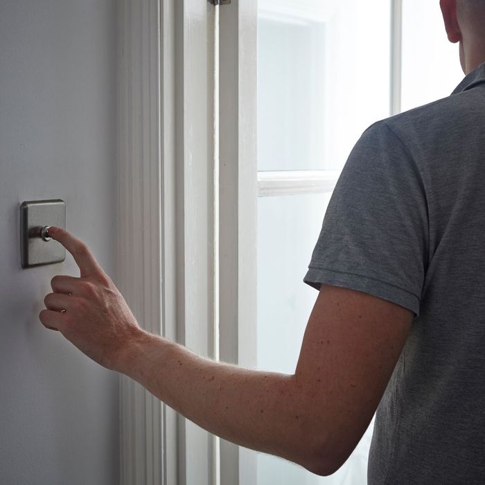 Man turning on a light switch.