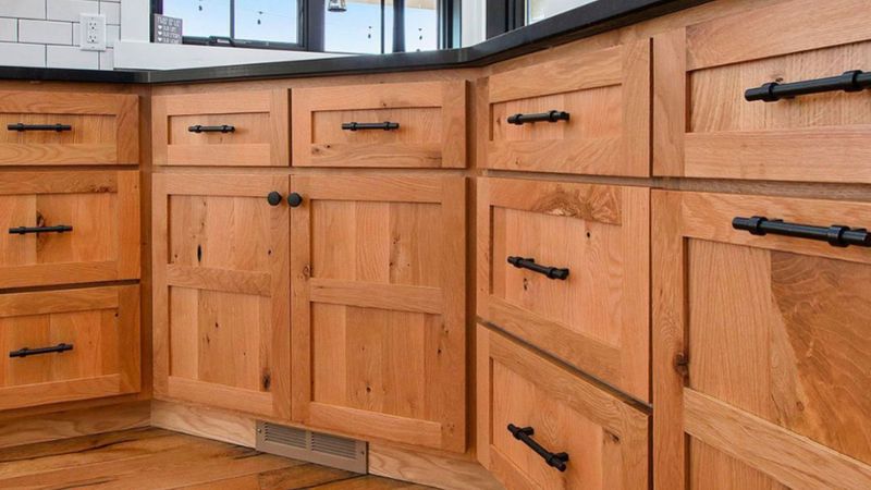 wood cabinets in kitchen with black handles