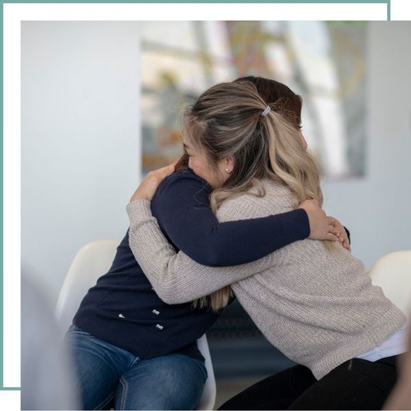 two women hugging in therapy