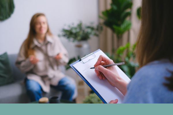 therapist writing on clipboard