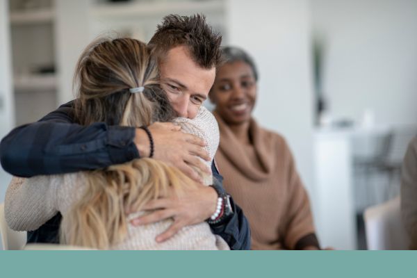 man and woman hugging in group therapy