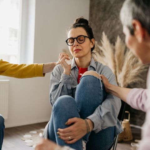 woman being consoled as she cries in therapy