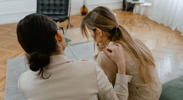 woman putting her hand on other woman's shoulder woman putting her hand on other woman's shoulder