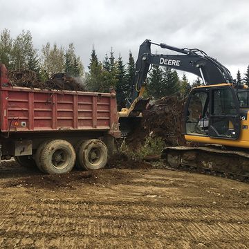 Excavator loading items into dump truck