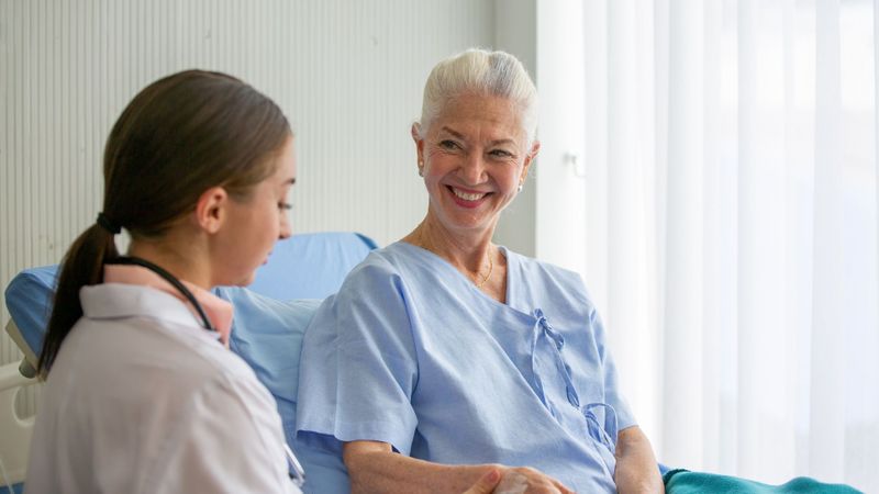caregiver with patient in hospital bed