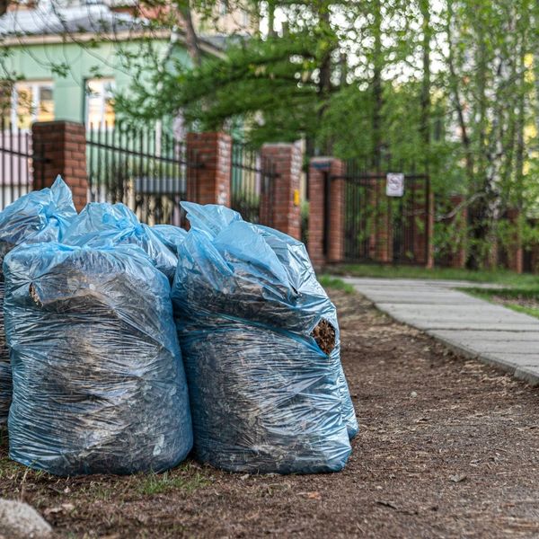 bags full of scraps sit outside of a residential home