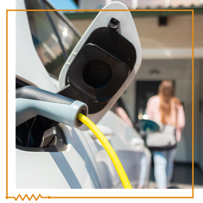 car charging as woman walks toward the house