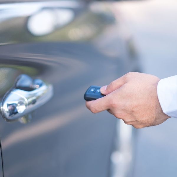 Person unlocking their car with key remote