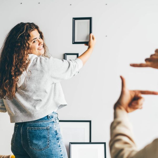 Woman hanging up picture frames