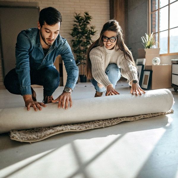Two people rolling up a rug