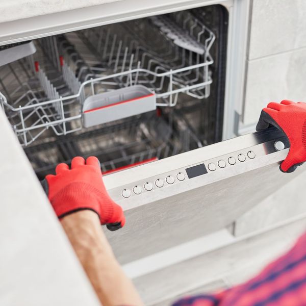 person fixing a dishwasher