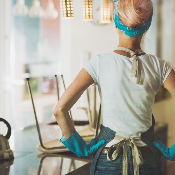 A woman with cleaning gloves and apron on