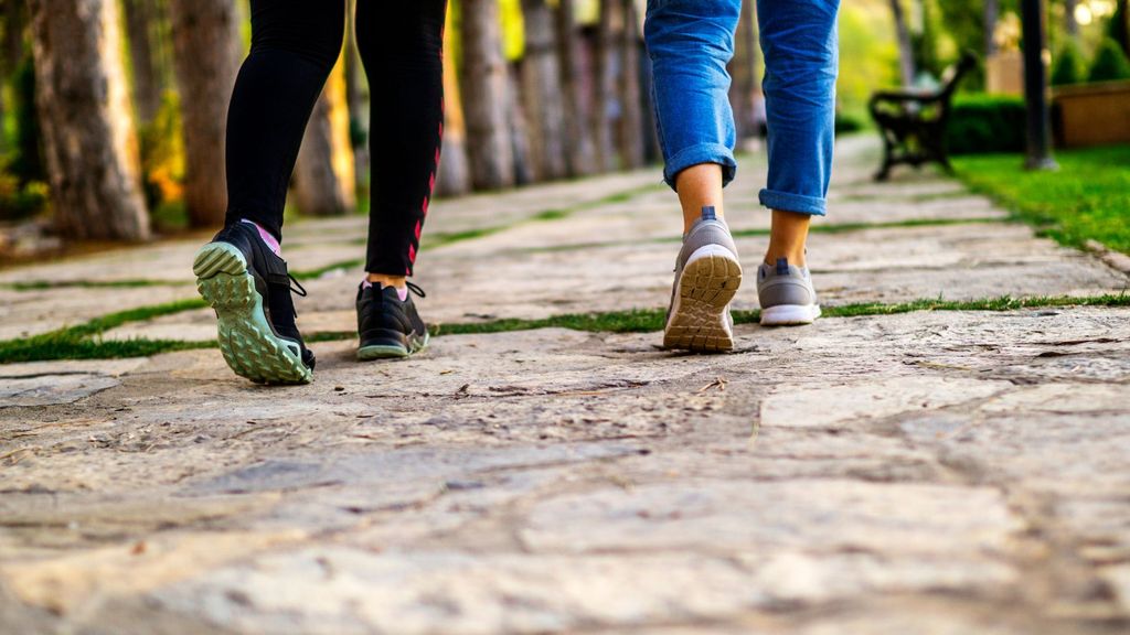 Two women walking on a trail in town