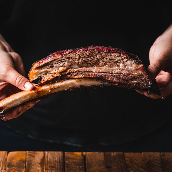 A person holding up a perfectly smoked sparerib