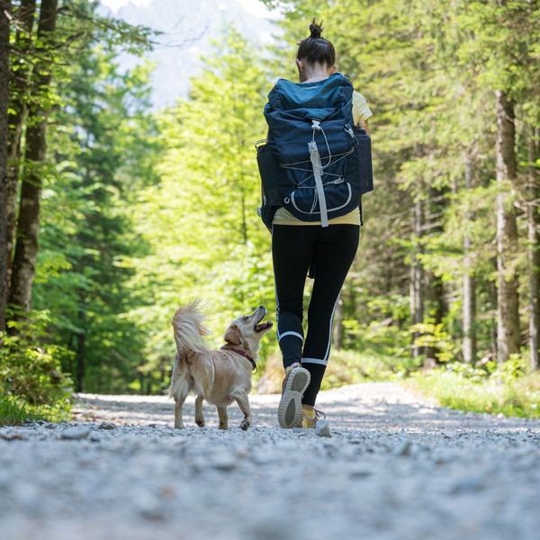 A woman walking down a trail with her dog