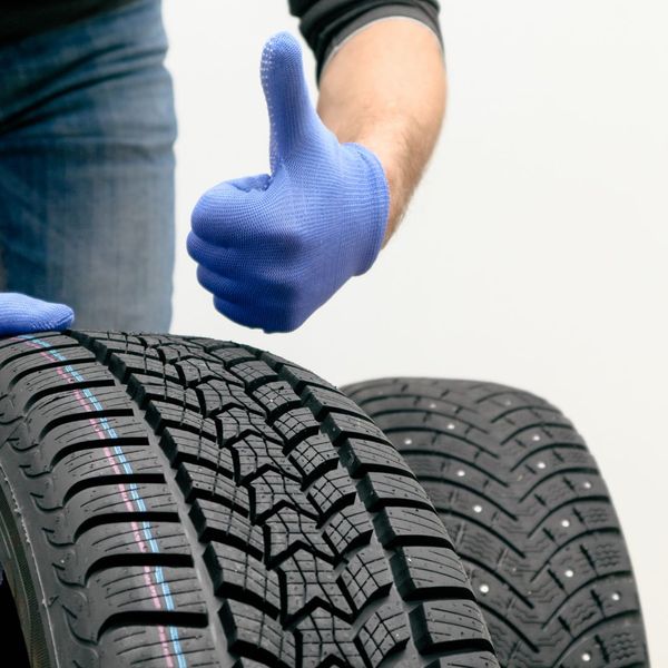 A person checking out new tires giving a thumbs up